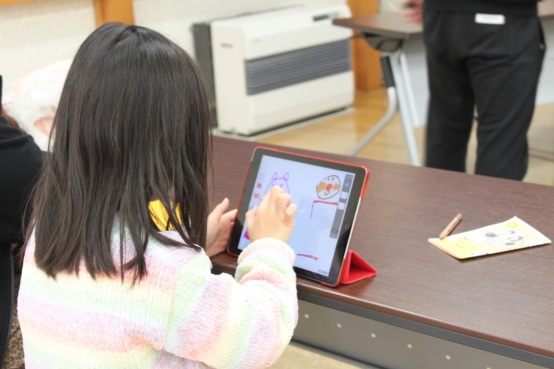 タブレットでお絵かきを楽しむ子どもの写真